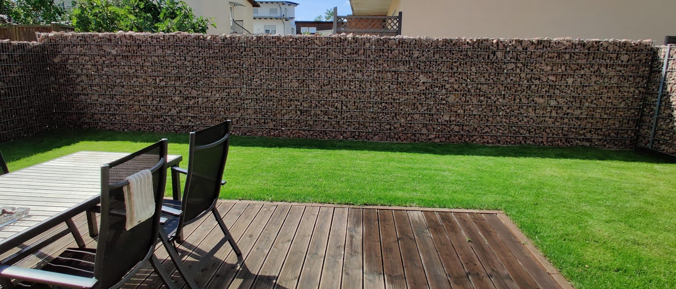 Neu angelegter Garten mit Rollrasen, Holzterrasse und Gabionenwand