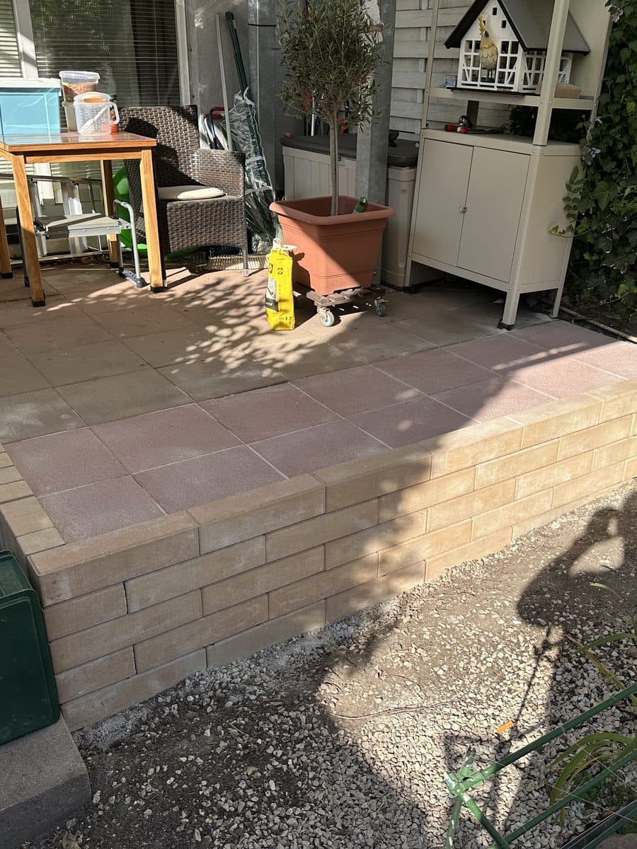 Erweiterte Terrasse mit neuen Platten und Stützmauer