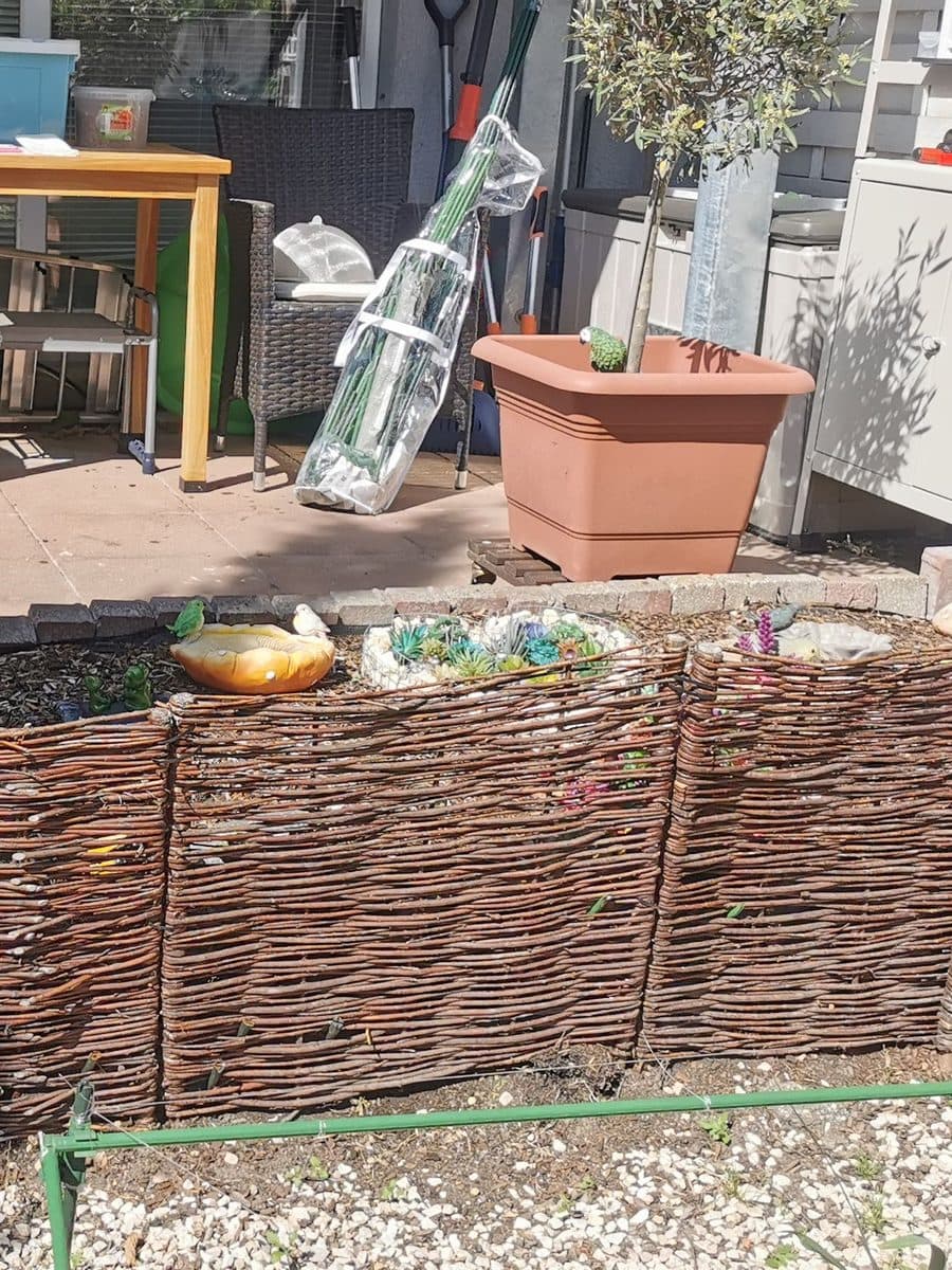 Terrasse mit Beet und Weidenzaun vor dem Umbau